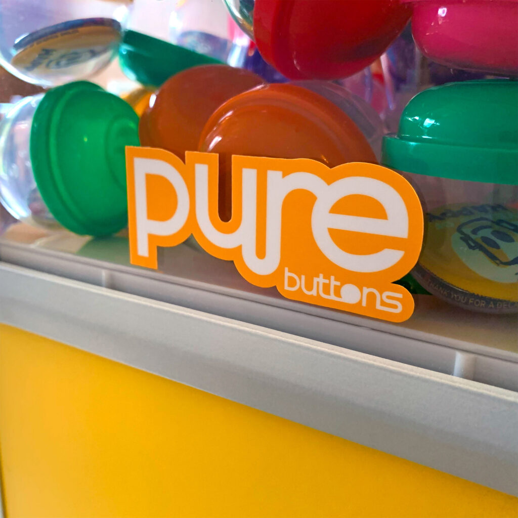 Pure Buttons logo die cut sticker applied to vending machine side windows